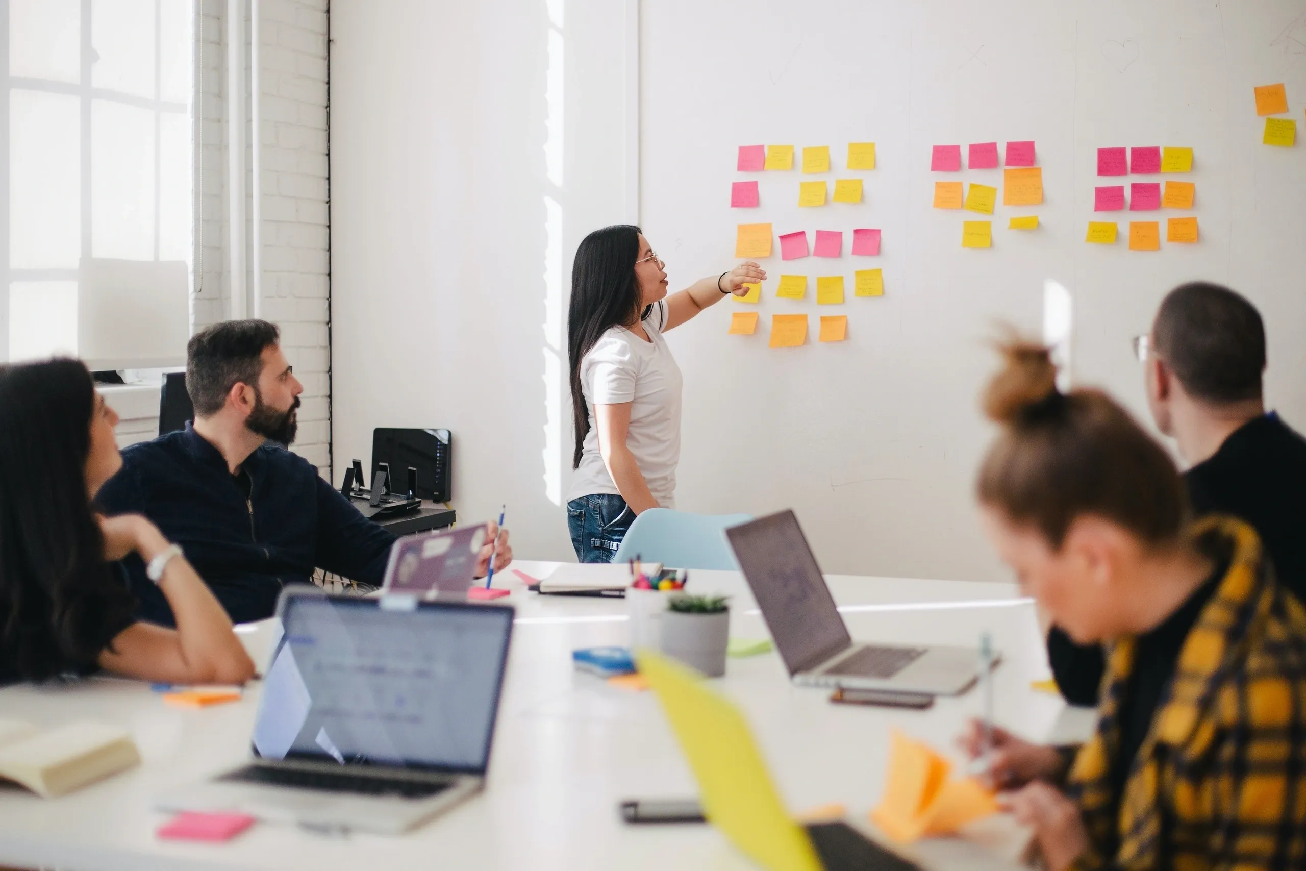 Team in a meeting room planning with sticky notes on a wall